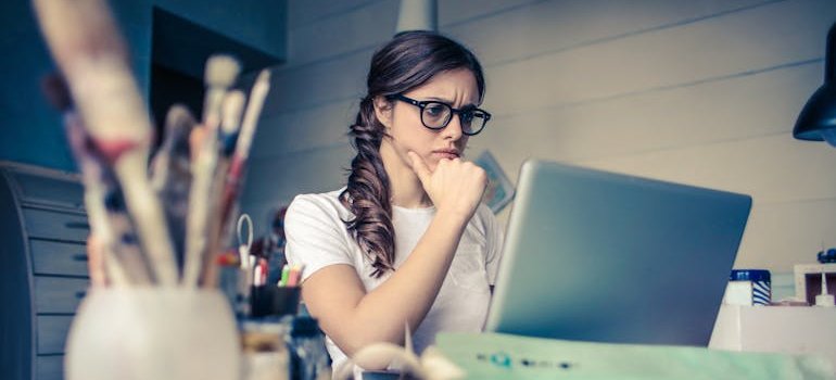 A young woman researching storage facilities online to find affordable storage in Morissania.