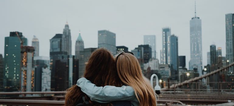 Two friends looking at the landscape of New York and you should take your time when renting your first apartment in Manhattan