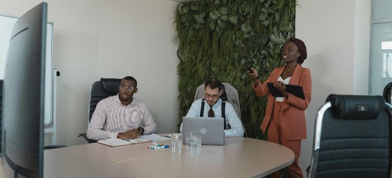 A team of office workers looking at a monitor.