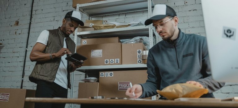Two workers packing boxes for a storage unit.