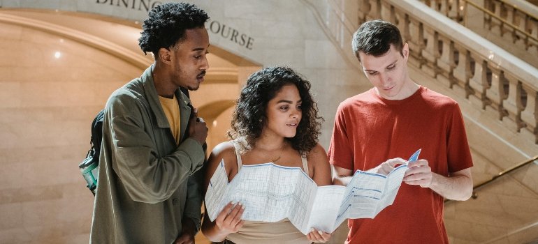 Three friends looking at a map after starting a new life in the Bronx.