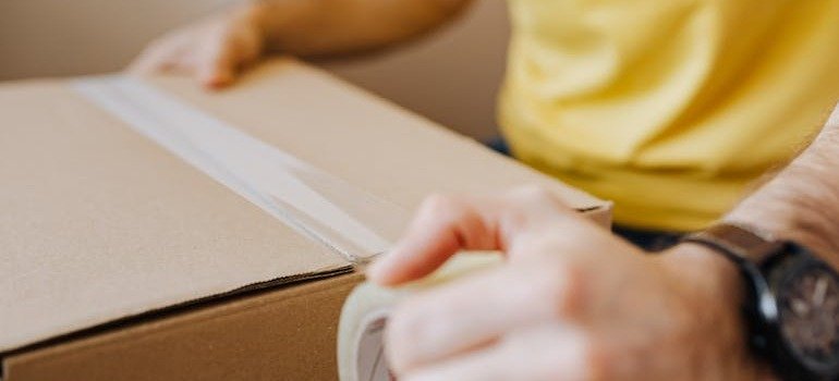 A person closing a moving box after exploring the qualities renters seek in a storage unit in NYC.
