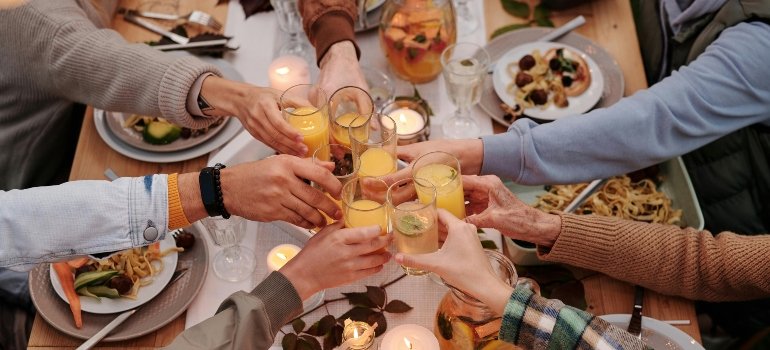 Friends and family sharing a meal and toasting, representing the community spirit of living and working in the Bronx.