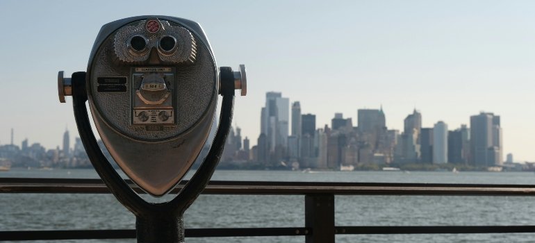 Coin-operated binocular viewing the New York City skyline, highlighting how storage costs vary across NYC depending on the location.