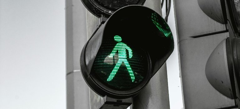 Green walk sign signaling pedestrians to cross safely, highlighting how new residents think about life in Brooklyn with its bustling streets.