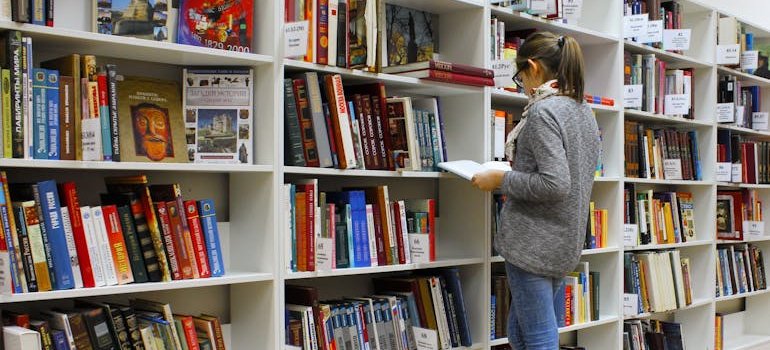 A student going through books in a library, as students are frequent storage users.