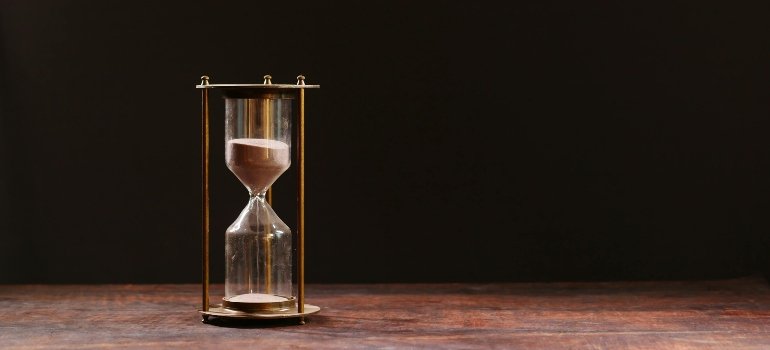 An hourglass on a wooden table.