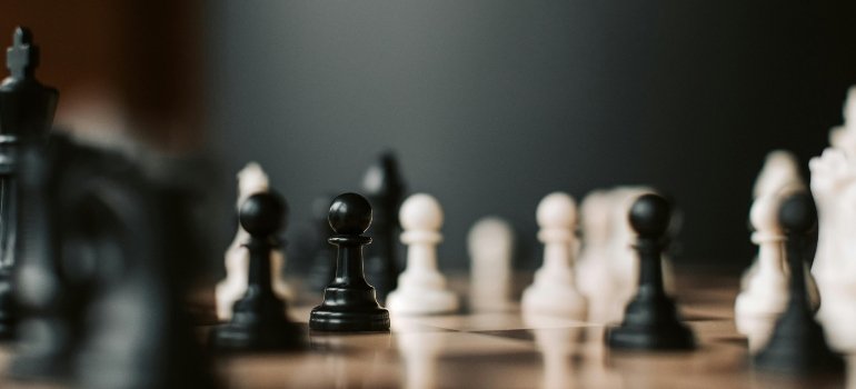 A chess table representing the challenges of securing a job before moving to Queens.