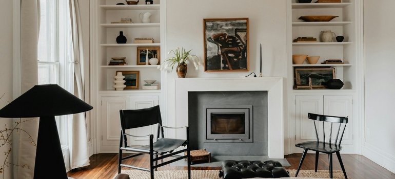 A living room with a fireplace filled with artwork.