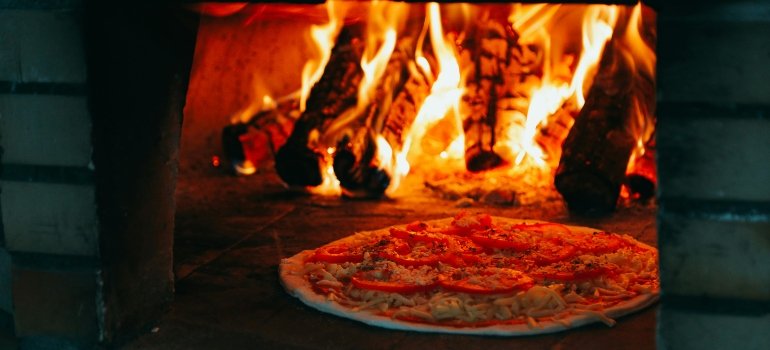 Pizza cooking in a wood-fired oven in Staten Island since eating out is in the monthly expenses in Staten Island.