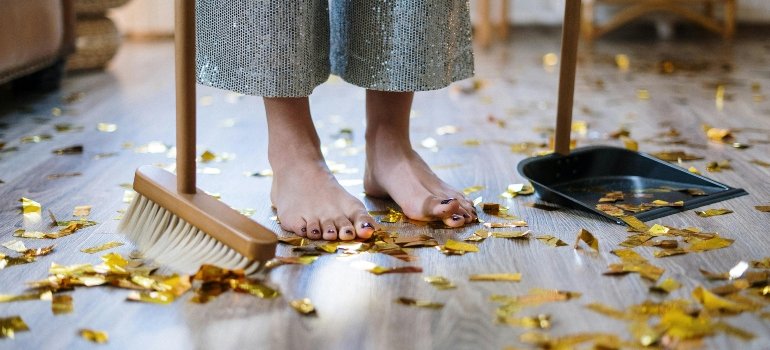 A woman sweeping up confetti.
