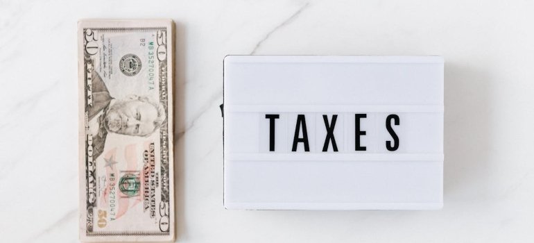 A dollar bill and taxes sign