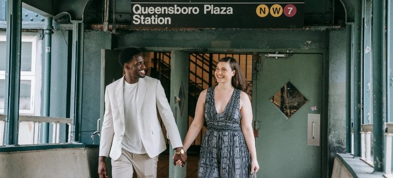 A couple walking through Queensboro Plaza Station.