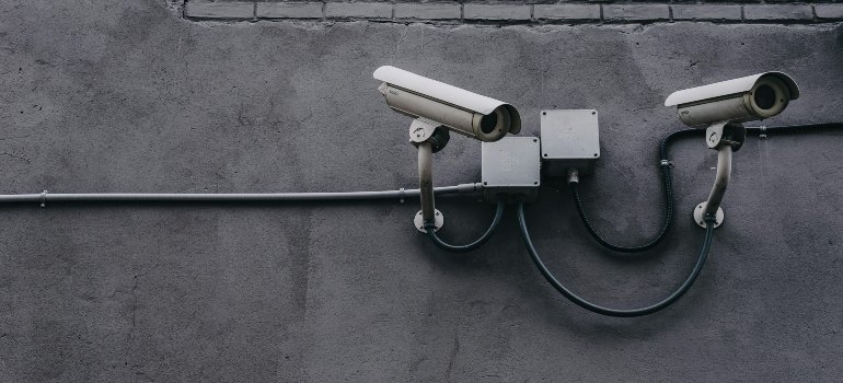 Two surveillance cameras mounted on a wall, emphasizing security for self-storage in Brooklyn.