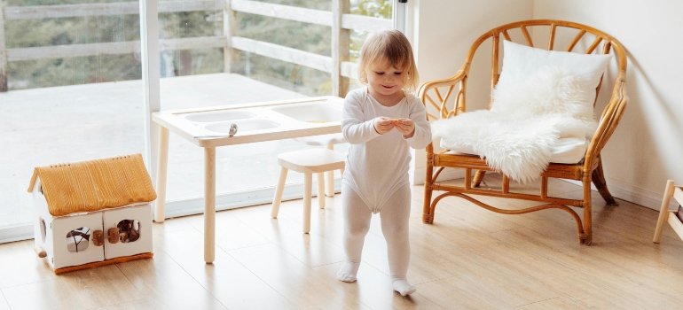 A toddler walking in a bright living space, showing the joy of a clutter-free, downsized home in Queens.