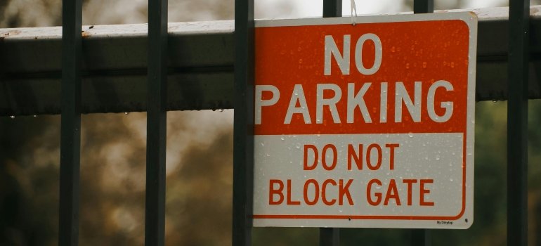 Close-up of a "No Parking - Do Not Block Gate" sign, emphasizing the importance of following parking regulations to avoid fines when moving in NYC.
