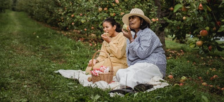 Two women enjoying a quiet picnic as you will too ater you recognize the time to downsize your Queens home.