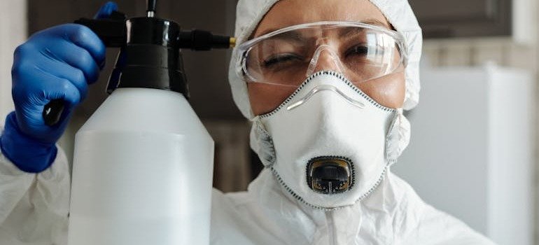A person in a white suite with a plastic bottle with liquid in it.