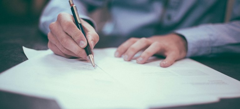 A person is signing documents after renting storage in other boroughs.