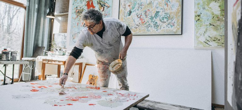 An artist painting on a canvas in the studio.