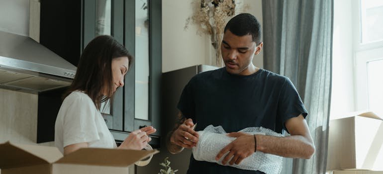 Couple invoved in packing to safeguard high-value items in storage.