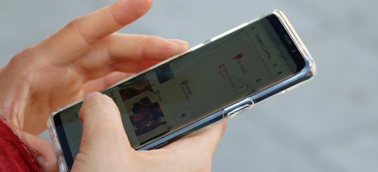 A person is browsing a location by using the phone and thinking about self-storage vs. full-service storage.