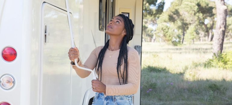 A woman standing next to an RV.