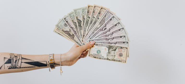A person holding a lot fo dollar bills.