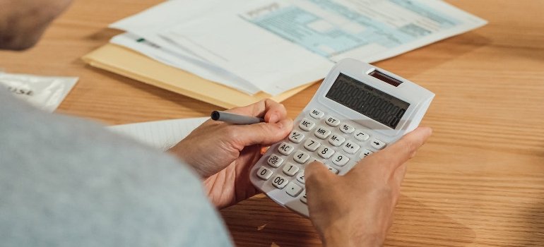 A person using a calculator while looking for profitable investment properties in Manhattan.
