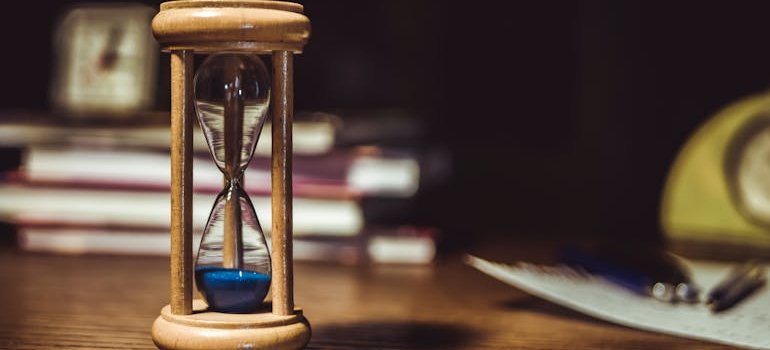 An hourglass on a desk symbolizing the importance of rent duration when renting storage in NYC for even planners and suppliers.