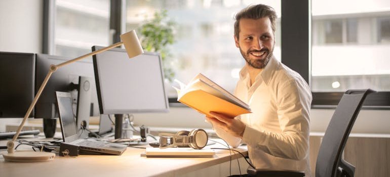 A person in the office smiling after reading about a move to Manhattan with your partner.