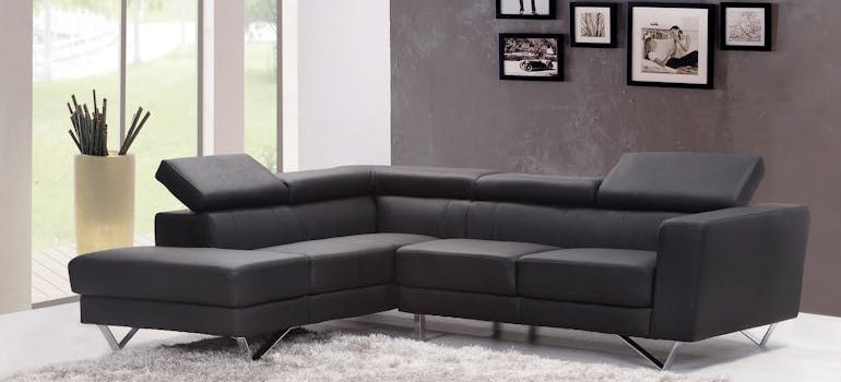 A picture of a beautiful apartment interior with a black sofa.
