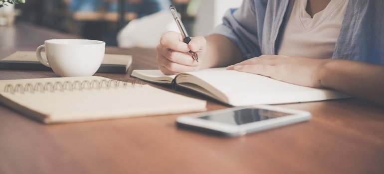 A person is taking notes while browsing for storage.