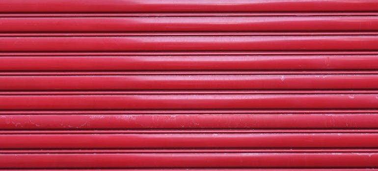 A shut red door of a storage unit.