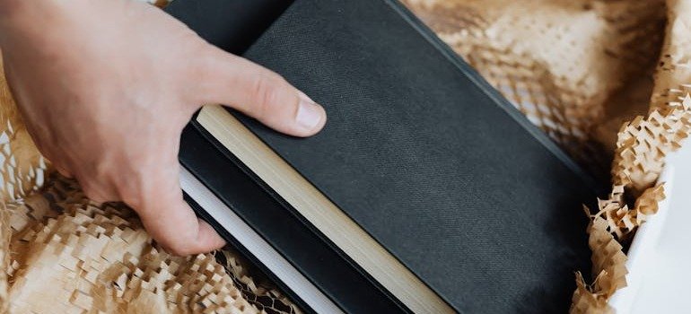 A person packing books after exploring NYC storage solutions for college students.