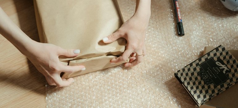 A person wrapping a package before putting it in short-term storage for busy young families.