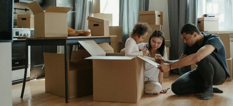 A family surrounded with moving boxes, preparing to pack up their home.