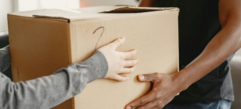 two people holding a cardboard box