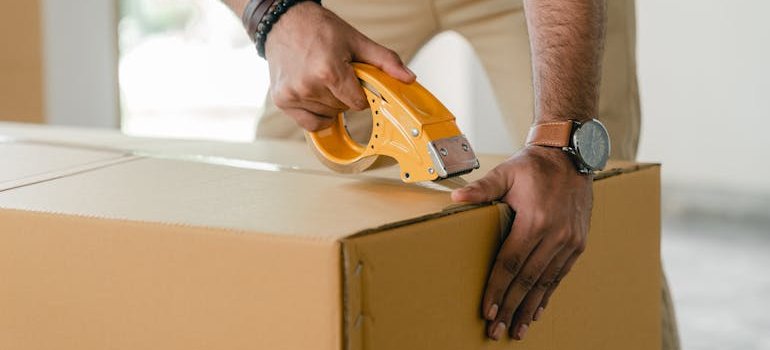 A person taping a box after exploring flexible storage options in NYC during the off-season