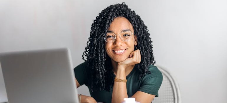 A person using a computer and smiling happily.