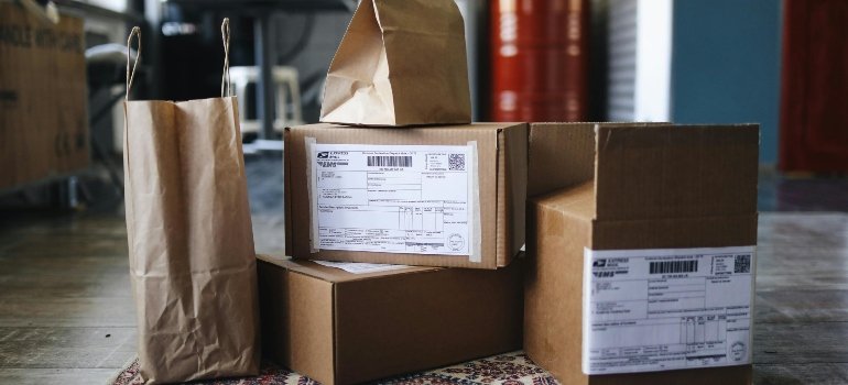 A stack of brown shipping boxes with mailing labels, ready for delivery.
