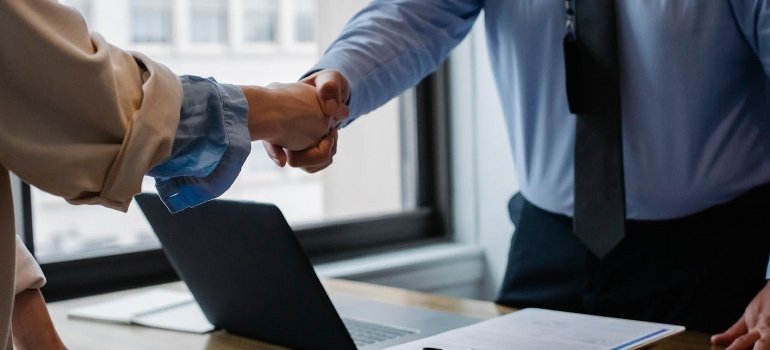Two persons shaking hands while talking about renting storage units in NYC for businesses.