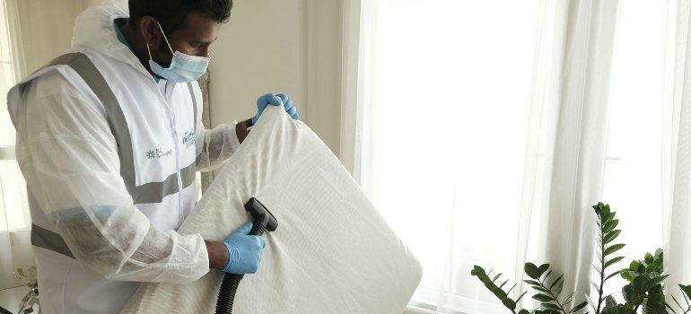 A specialist cleaning a mattress before storing mattrasses and sofas.