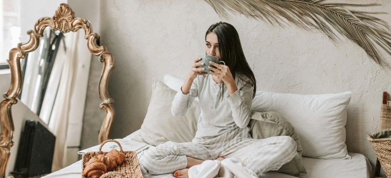 A woman having breakfast in bed thinking of ways for balancing work and life while living in the Bronx.