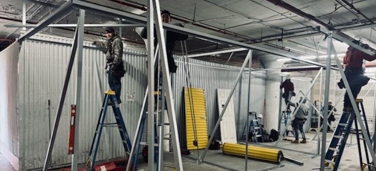 two workers assembling first-floor storage units