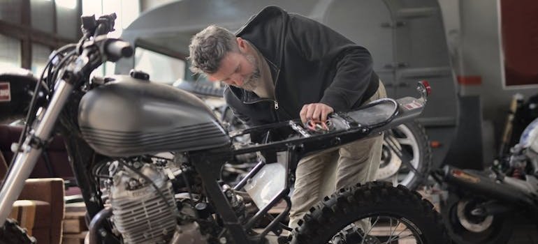 Man doing upkeep on his motorcycle.