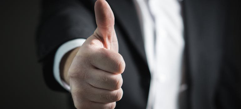 A person showing a thumb up for all the reasons that reveal what makes Manhattan so appealing to young professionals.