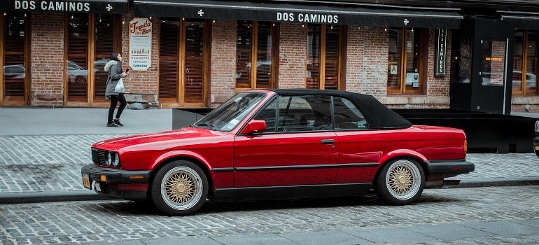 A red car is parked in Manhattan.