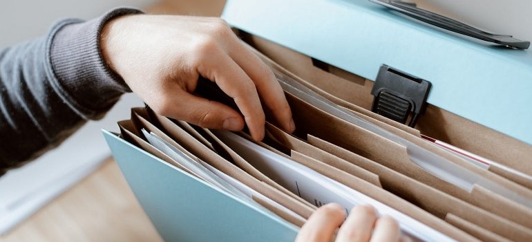 A person is choosing a document in the folder.