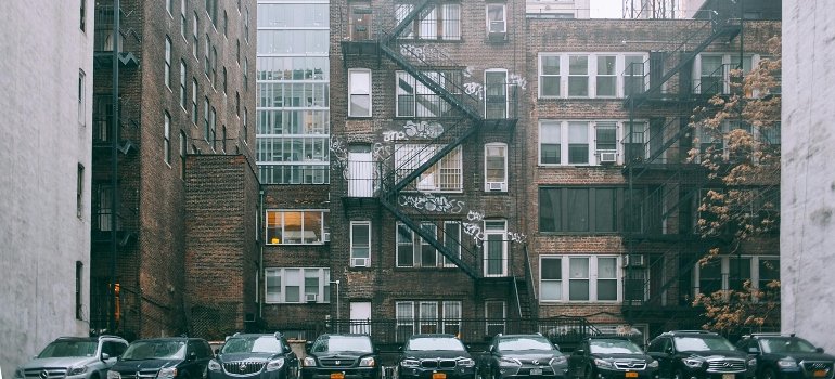 Cars lined up side by side in an urban parking space.